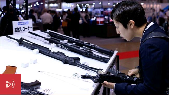 Photo: A man handles a fake gun on show at the Japan Models and Hobby Show 2016. Credit: Getty Images